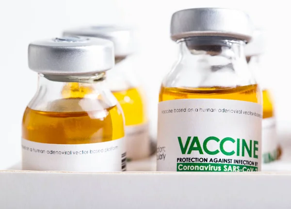 Vials of coronavirus medicine are in packaging on a white background. Vaccine test concept in a laboratory