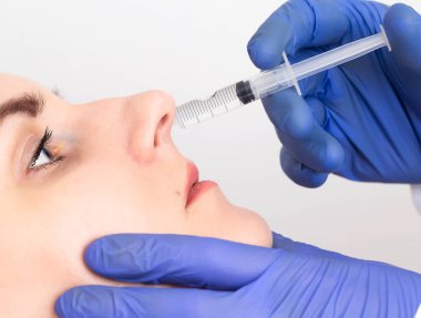 Doktor, kız hastaya yapılan işlemi yakın plan intranasal blok haline getiriyor. Kuru ve yanan burun ve endonazal için tedavi kavramı