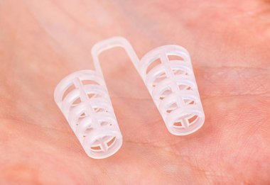 Bir insanın avucundaki burun için horlama önleyici cihaz, yakın plan.