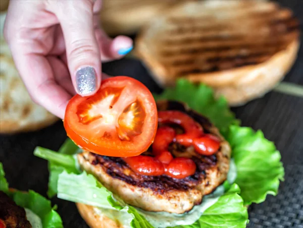 Kvinnas Hand Lägger Ner Bit Tomat Utsökt Hemlagad Hamburgare Handgjorda — Stockfoto