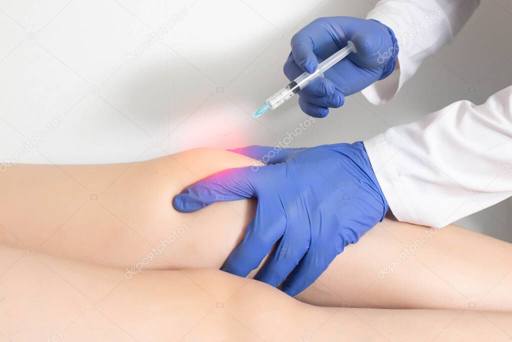 The doctor injects an ozone-oxygen mixture into the patient's knee joint to relieve muscle spasm and inflammation. Ozone therapy, copy space for text, treatment