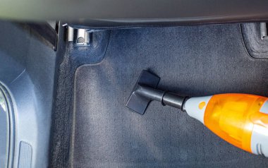 Modern bir arabanın içini toz ve tozdan elektrikli süpürgeyle temizlemek.