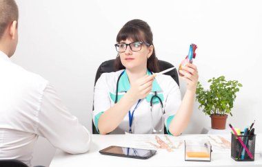 Doktor-kardiyolog-psikoterapist resepsiyonundaki genç hasta. Psikolojik bozukluk ve kalp ağrısı, kardiyak nevroz, kardiyofobi, psikoterapi, psikosomatik...