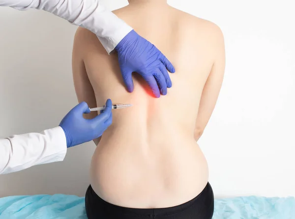 Doktor, omurga hastalıklarını tedavi etmek ve sırt kaslarını gevşetmek için bir kızın sırtına ozon-oksijen karışımı enjekte eder. Modern ozon terapisi yöntemi