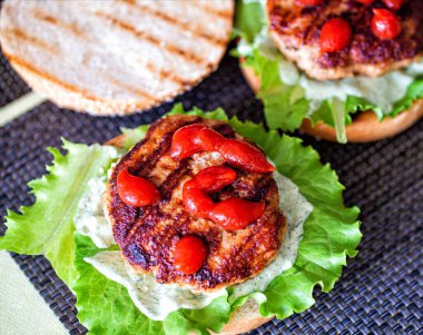 Pirzola, salata, domates ve susamlı hamburgerle nefis ev yapımı hamburgerler. Lezzetli ev yapımı yemekler, fast food, çizburger.