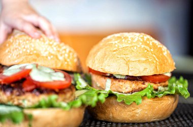 Pirzola, salata, domates ve susamlı hamburgerle nefis ev yapımı hamburgerler. Lezzetli ev yemekleri, fast food.