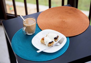 Balkonda sabah kahvaltısı, ekşi kremalı krep ve etle doldurulmuş et, sütlü kahve, iştah.