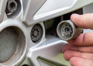 Araba tekerleğinde gizli bir cıvata. Hırsızlık önleyici koruma, makro. Sanayi