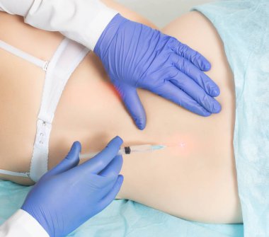 Doktor, sırtı ağrıyan ve kuyruk sokumu olan bir kadının omurgasına tıbbi abluka uygular.