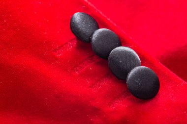 Düğmeleri ve arka planı olan kırmızı şık bir ceket. Şık kıyafetler, makro, zarif.