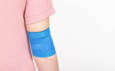 Kızın dirsek ekleminde elastik bandaj var. Dirsek saplantı konsepti burkulma ve travma için, metin için kopyalama alanı. Sargılama