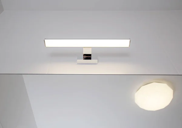 Stylish LED wall light above the bathroom mirror. Modern lighting