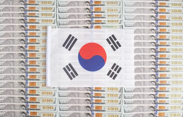 South Korea flag on a background from dollar banknotes. Concept of the relationship of the South korea money in relation to the dollar, the country\'s economy, industry