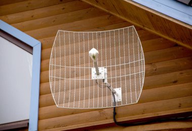 Hücresel iletişim sinyalini yükseltmek için parabolik anten ve bir kır evine kurulmuş internet. Ülkedeki 4G ve 5G internet sinyallerinin güçlendirilmesi