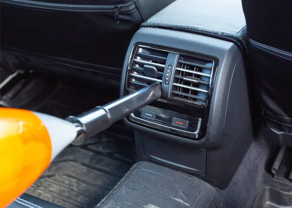 Dry cleaning in the passenger compartment of a car with a car vacuum cleaner from dust and dirt, background