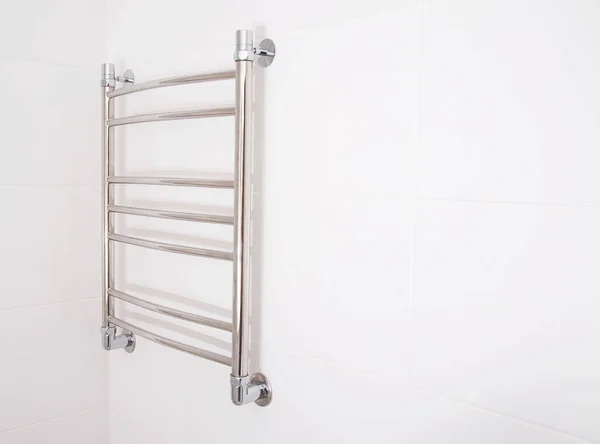 Modern stainless steel heated towel rail in the bathroom. Plumbing heating device