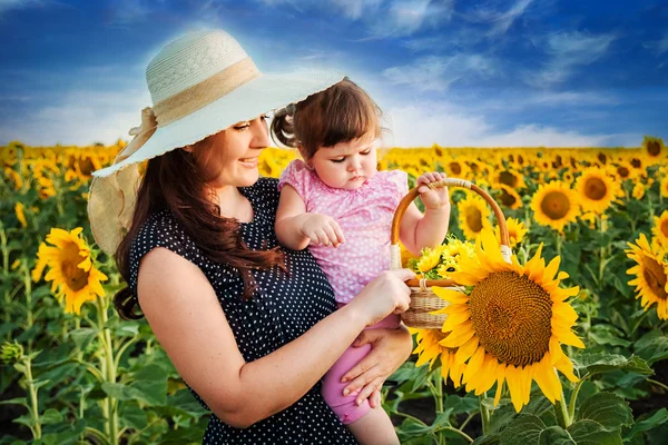 Mère avec fille sur le terrain avec des tournesols — Photo