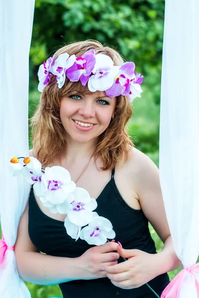 Portret van een mooi meisje in een krans van bloemen — Stockfoto