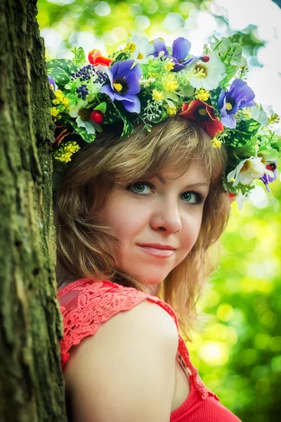 Portret van een mooi meisje in een krans van bloemen — Stockfoto