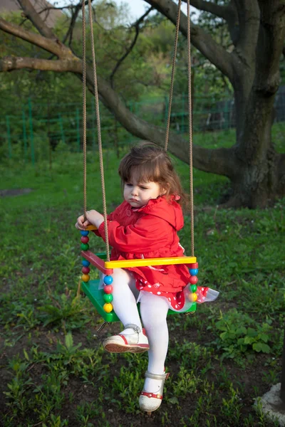 Капризная маленькая девочка на качелях — стоковое фото