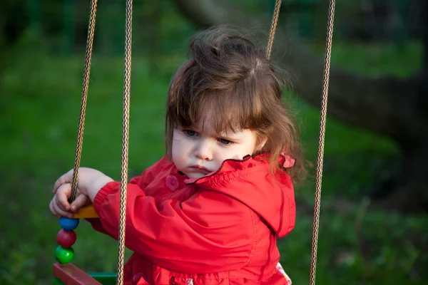 Capricious little girl on a swing — Stock Photo, Image