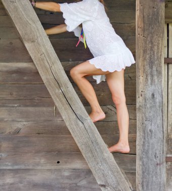 Kız ahıra giden ahşap merdivenleri tırmanır.