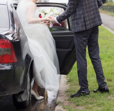 Gelin arabadan bir buketle iniyor.