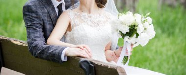 Parkta düğün buketi olan gelin ve damat