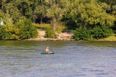 Dinyeper 'da şişme bir teknede bir balıkçı. Amatörler için spor ve eğlence