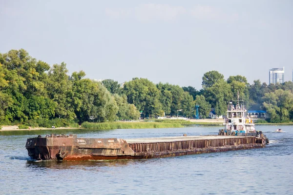 The barge sails along the Dnieper River. Delivery of goods by water