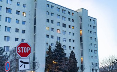 Alacakaranlıkta apartman bloğu. Önünde dur işareti var.