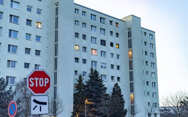 Alacakaranlıkta apartman bloğu. Önünde dur işareti var.