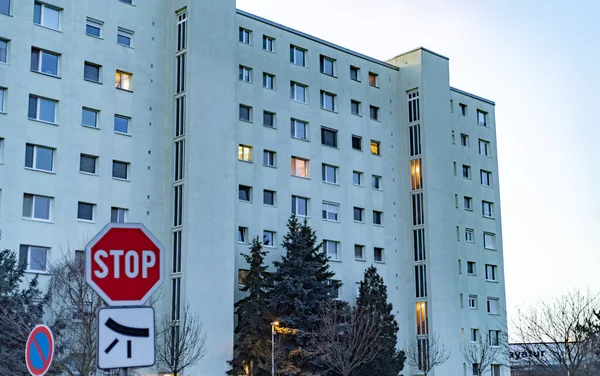 Alacakaranlıkta apartman bloğu. Önünde dur işareti var.