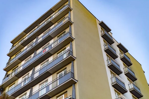 Mavi gökyüzüne karşı geometrik balkonları olan modern apartman dairesi.