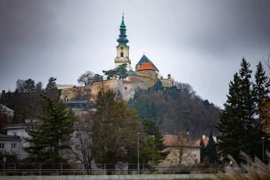 Tepedeki Nitra Kalesi kışın dramatik bulutlu gökyüzü altında, Slovakya