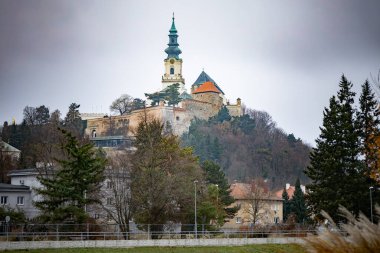 Tepedeki Nitra Kalesi kışın dramatik bulutlu gökyüzü altında, Slovakya