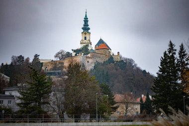 Tepedeki Nitra Kalesi kışın dramatik bulutlu gökyüzü altında, Slovakya