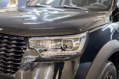 LED optik ve krom ızgaralı modern bir SUV siyah araba farının yakın çekimi.