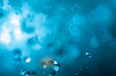 Mavi zemin üzerinde bir damla suyun makro görüntüsü