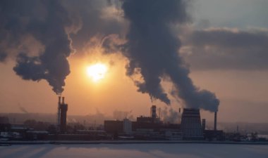 Buz tutmuş bir fabrika bacasından duman çıkıyor.