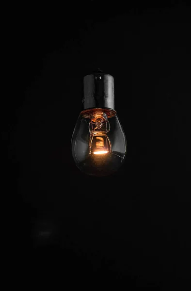 Old dusty light bulb glowing in the dark — Stock Photo, Image