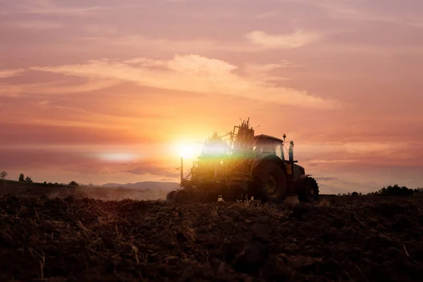 日落时在农田里工作的机器 — 图库照片