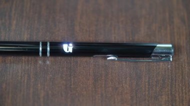 Siyah metal bir kaleme lazer oyması. Modern endüstriyel teknolojiler. İyi şanslar. 