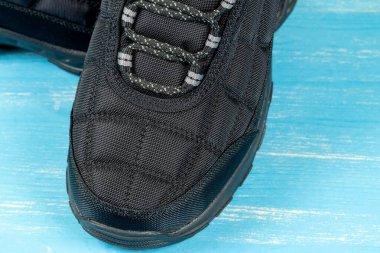 Mavi ahşap arka planda kış botları 