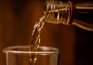 Brendi bardağa dökülüyor. Bir makro resim.