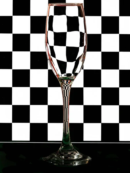 A champagne flute against a checkered background.