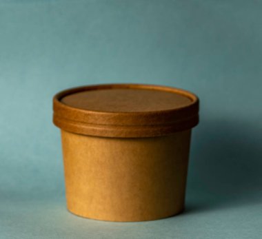 Mavi arka planda izole edilmiş yuvarlak küresel bir karton kap..