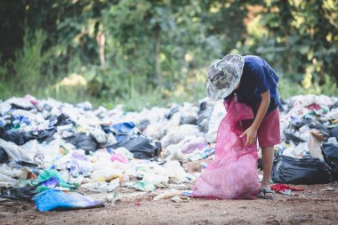 Zavallı çocuk geçimini sağlamak için çuvalında çöp topluyor fakir çocuklar ve yoksulluk kavramı.