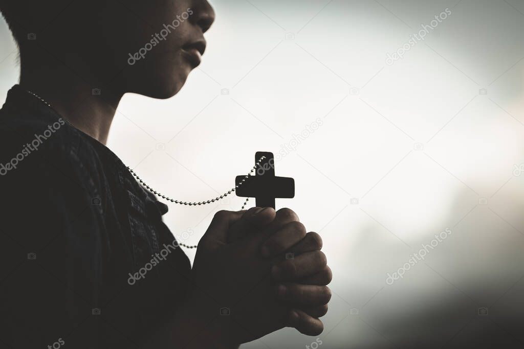 Boy hands holding a holy cross and praying to God, Child Praying for God Religion.