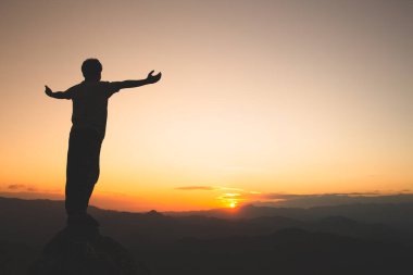 İnsanoğlu dağın tepesinde ve günbatımında elini kaldırır, Özgürlük ve seyahat macerası konsepti. Dini inançlar, alanı kopyala.